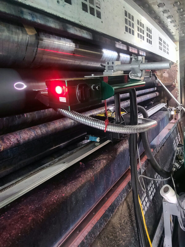 Portable laser system positioned for on-press anilox roll cleaning